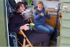 Jan and Joan having a cup of tea in the shed at the allotment
